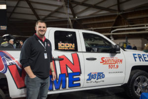 Frei Chevrolet's Andy Grundstrom next to the Silverado Summer Giveaway Grand Prize.