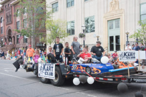 All of the kids from the Marquette Kart Club where sitting in their karts on the float.
