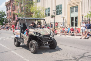 Mark Evans and Adam Carpenter driving along in the side-by-side.